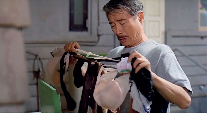 El Sr. Chu recogiendo ropa de la lavadora