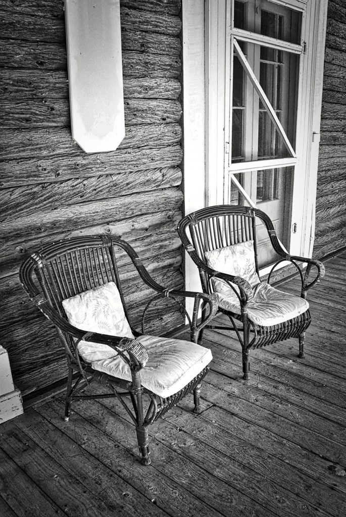 dos sillas en un porche de madera
